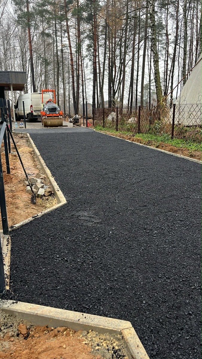 Asfaltuotas įvažiavimas prie privataus namo miškingoje teritorijoje