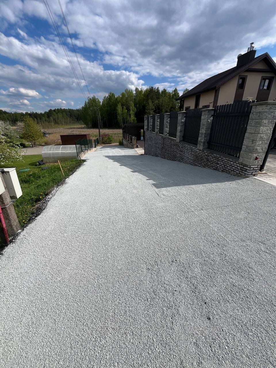 Frezuoto asfalto privažiavimas su skaldele prie mūrinės tvoros