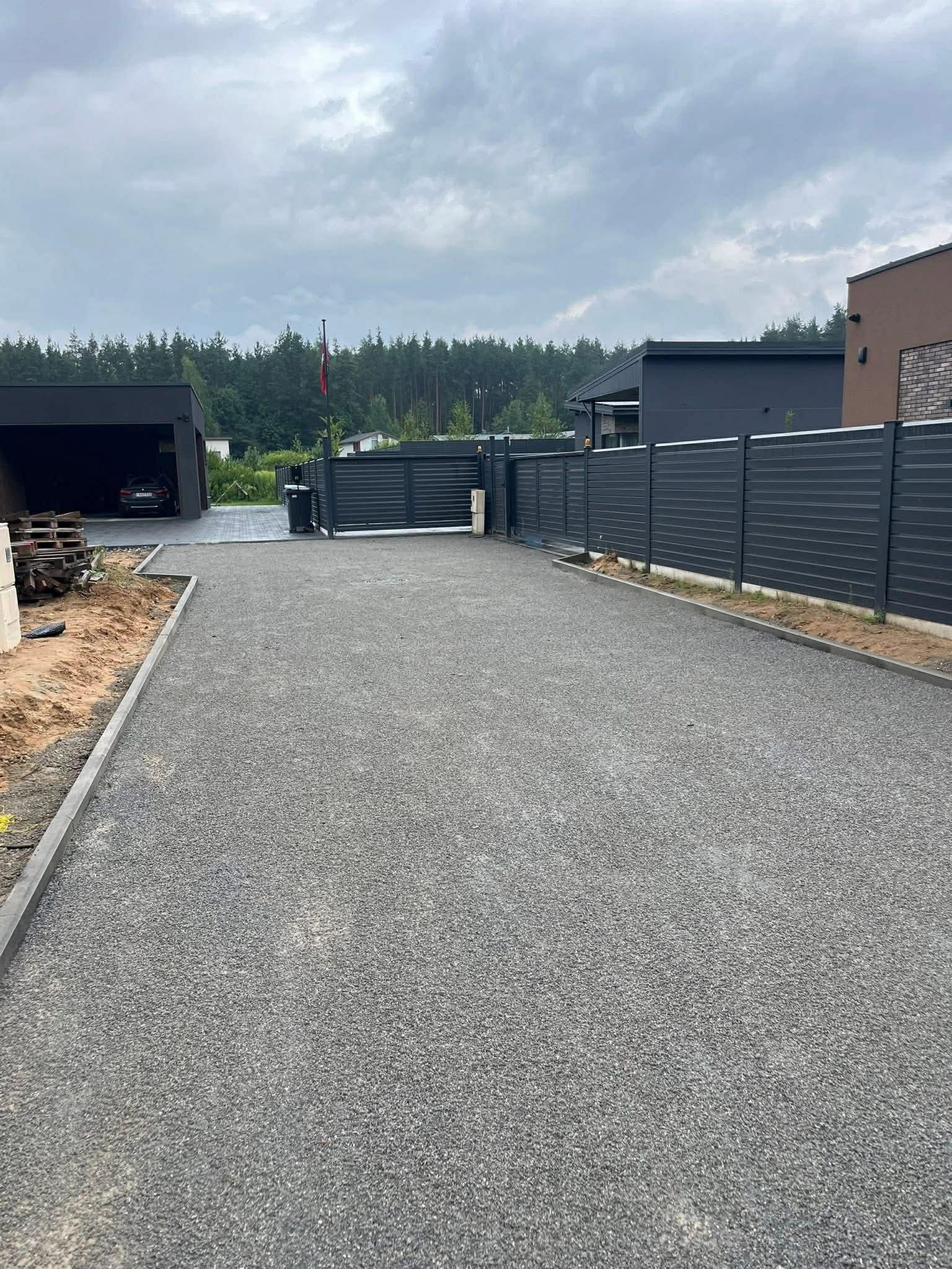Frezuoto asfalto kiemas prie garažo su metaline tvora
